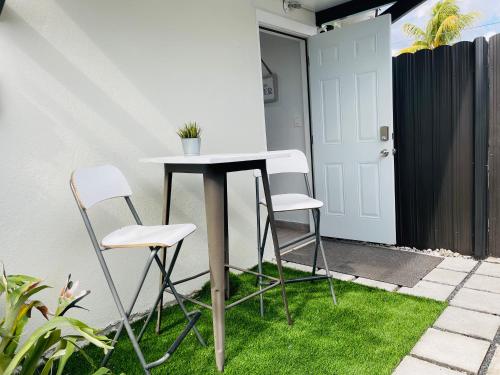 a table and two chairs on a patio with grass at Nuvole Guest Suite in Miami