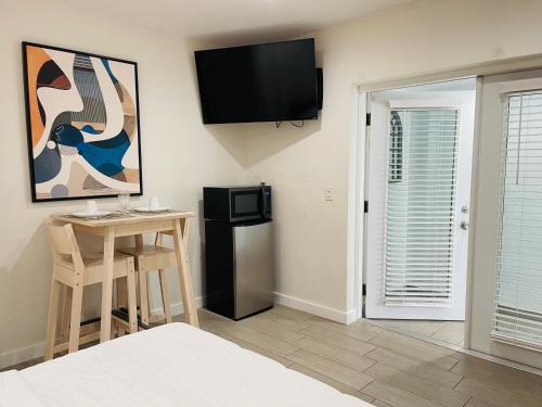 Habitación con mesa y TV en la pared. en Nuvole Guest Suite, en Miami