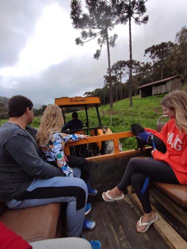 a group of people sitting on the back of a truck at Pousada Vale da Imbuia chalé para temporada in Urubici