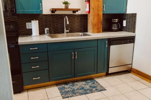 a kitchen with green cabinets and a sink at The Icon in Springfield