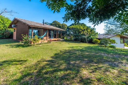 a house with a large yard with a swing at Pousada Watu Kerere in Praia do Rosa