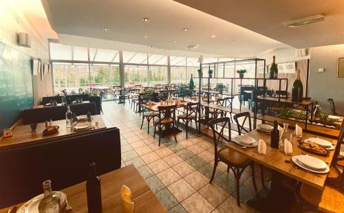 un restaurant avec des tables et des chaises dans une salle dans l'établissement la terrasse, à Larche