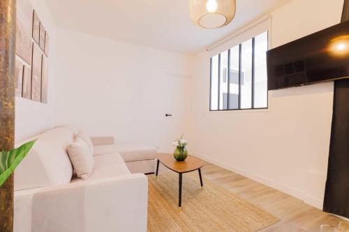 un salon avec un canapé blanc et une table dans l'établissement Exceptionnel appartement à proximité de Montmartre!, à Paris