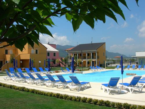 a row of lounge chairs next to a swimming pool at Residence Borgomare in Albenga