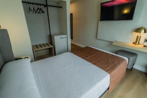 a small room with a bed and a mirror at HOTEL CORONA DE PADRÓN in Padrón