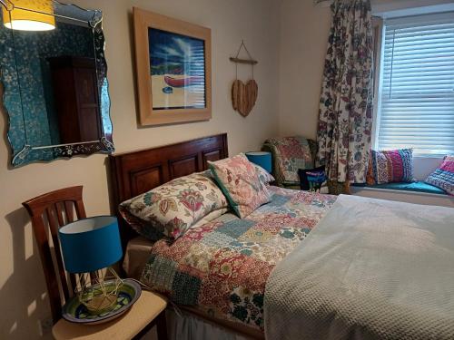 a bedroom with a bed and a table and a window at The Hideaway in Peebles