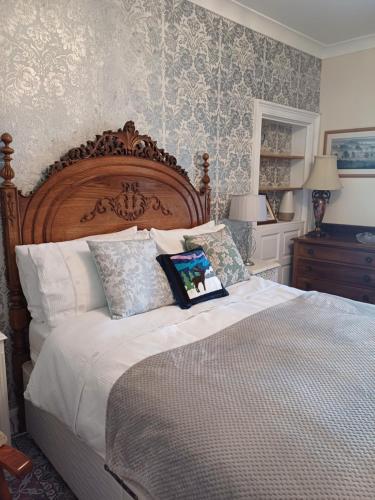 um quarto com uma cama grande e uma cabeceira em madeira em The Hideaway em Peebles