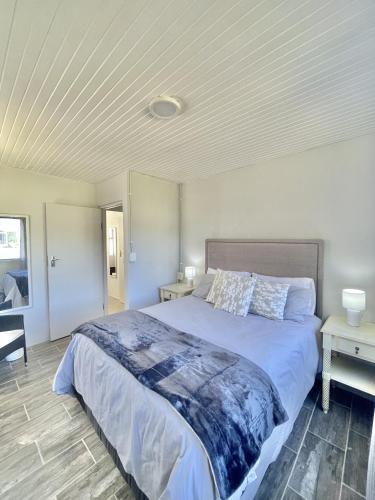 una camera da letto con un letto grande e due tavoli di LTB-Waterkant Cottage a Malgas