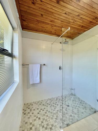 un bagno con doccia con porta in vetro di LTB-Waterkant Cottage a Malgas