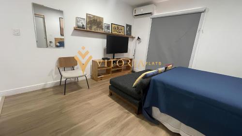 een slaapkamer met een bed, een tv en een stoel bij DOWNTOWN BUDGET REFUGE in Sao Paulo