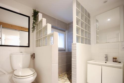 une salle de bain blanche avec des toilettes et un lavabo dans l'établissement Studio du Charme Médiéval ConciergerieDameCarcas, à Carcassonne