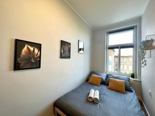 una camera da letto con un letto e due pantofole sopra di MMRent Sunflower Room a Danzica