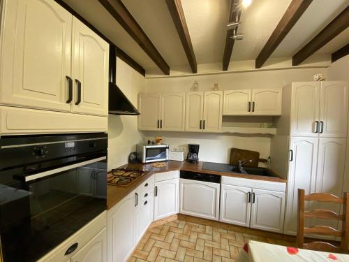 une cuisine avec des armoires blanches et des appareils noirs dans l'établissement Appartement spacieux, 9 personnes, 3 chambres, 1 mezzanine - ARA101, à Beaufort