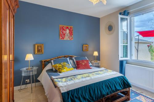 - une chambre bleue avec un lit et une fenêtre dans l'établissement Gîte le Chandon, à Amboise