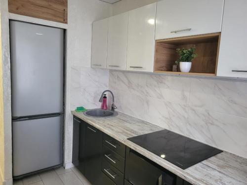 a kitchen with a sink and a refrigerator at квартира по суточно in Shchūchīnsk