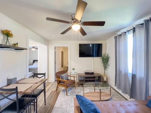 a living room with a ceiling fan and a table at 2BR Cedar Lane Road Retreat at Swamp Rabbit Trail! in Greenville