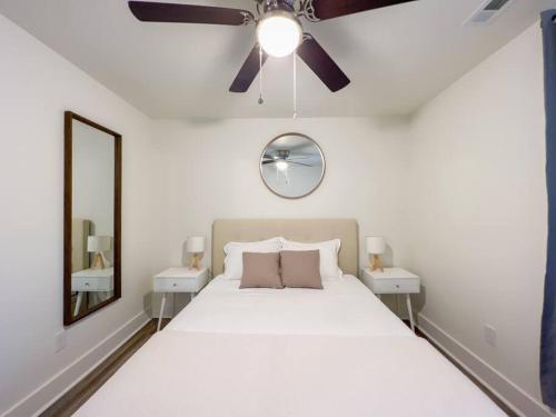 1 dormitorio con cama blanca y ventilador de techo en 2BR Cedar Lane Road Retreat at Swamp Rabbit Trail! en Greenville