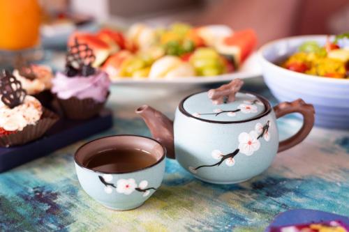 a table with two cups of coffee and a plate of cupcakes at HOTEL JS SOUVENIR in Dehradun
