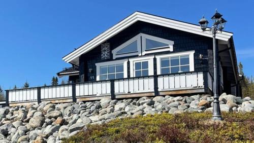 une maison noire au sommet d'un tas de rochers dans l'établissement Mountain Holiday Homes - Ottsjö, Trillevallen -Sweden, à Åre