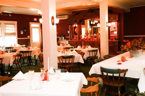 ein Esszimmer mit Tischen und Stühlen sowie weißen Tischdecken in der Unterkunft Fullerton Inn & Restaurant in Chester