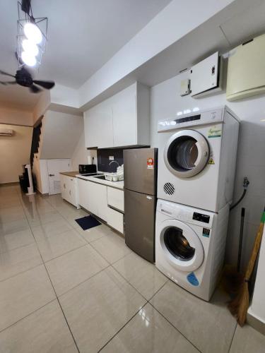 a kitchen with a washer and dryer in a room at Wanda Guest House Eclipse Cyberjaya in Cyberjaya