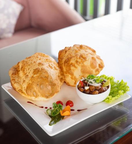 a plate of food with bread and salad on a table at HOTEL JS SOUVENIR in Dehradun