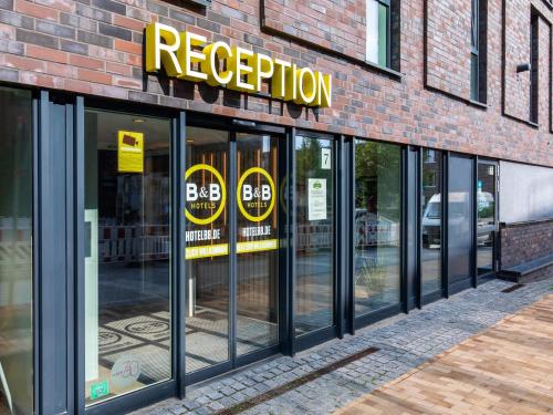 una tienda frente a un edificio de ladrillo con puertas giratorias en B&B Hotel Lübeck, en Lübeck