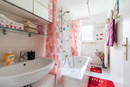 a white bathroom with a sink and a tub at Private Apartment in Hannover