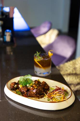 a plate of food on a table with a drink at HOTEL JS SOUVENIR in Dehradun