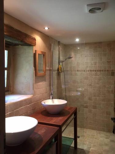 La salle de bains est pourvue d'un lavabo et d'une douche avec baignoire. dans l'établissement Grange périgourdine restaurée au calme, à Rouffignac-Saint-Cernin-de-Reilhac