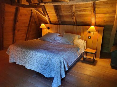une chambre avec un lit dans une pièce aux murs en bois dans l'établissement Grange périgourdine restaurée au calme, à Rouffignac-Saint-Cernin-de-Reilhac