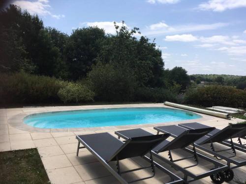 une piscine avec des chaises longues à côté dans l'établissement Grange périgourdine restaurée au calme, à Rouffignac-Saint-Cernin-de-Reilhac