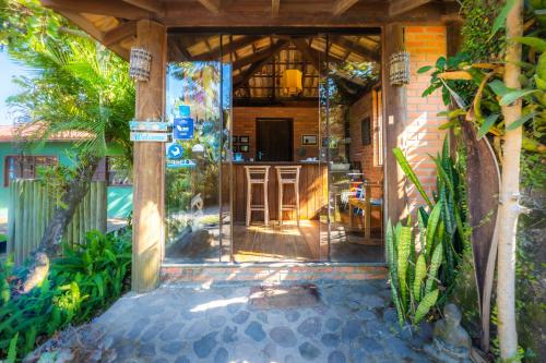 an open door of a house with a patio at Pousada Watu Kerere in Praia do Rosa