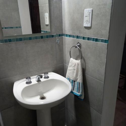 y baño con lavabo blanco y espejo. en Cabañas Plottier-Neuquén en Plottier