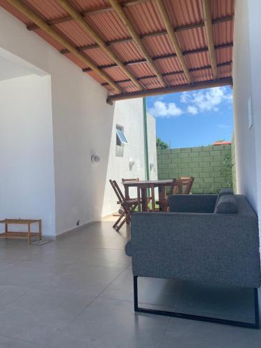 ein Wohnzimmer mit einem Sofa und einem Tisch in der Unterkunft Casa Solar - Praia do Francês in Marechal Deodoro