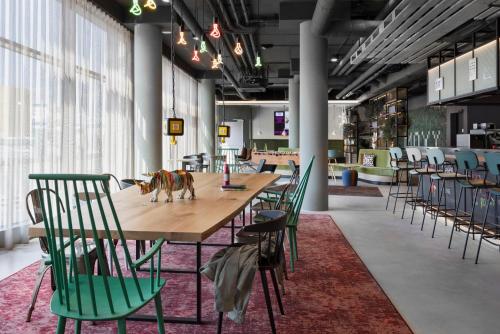 um quarto grande com uma mesa longa e cadeiras em Moxy Vienna City East em Viena