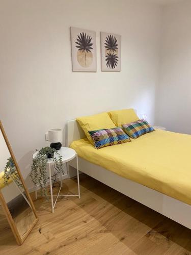 a bedroom with a yellow bed and a table at Apartamento HALO VIGO in Vigo