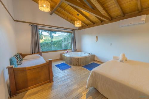 a bedroom with a bed and a bath tub at Pousada Watu Kerere in Praia do Rosa