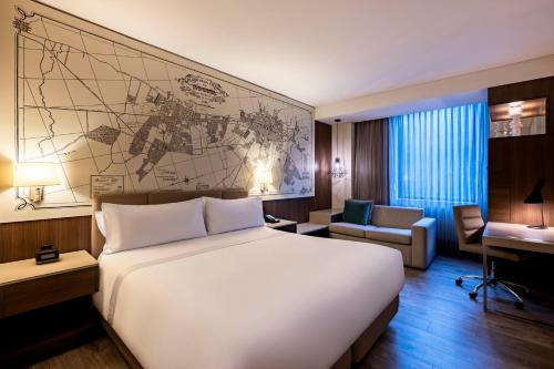 a hotel room with a large white bed and a desk at Courtyard by Marriott Bogota Airport in Bogotá