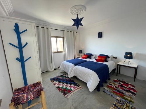 1 dormitorio con 2 camas y una estrella azul en la pared en La Maison de Mohamed en Ouassane
