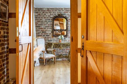 an open door to a room with a brick wall at La belle Maison in Sippenaeken