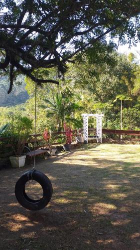a tire swing hanging from a tree in a yard at Sitio do Ma Vio in Governador Celso Ramos