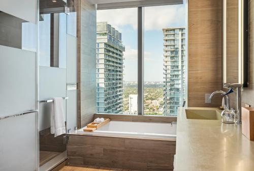 a bathroom with a bath tub and a large window at EAST Miami in Miami