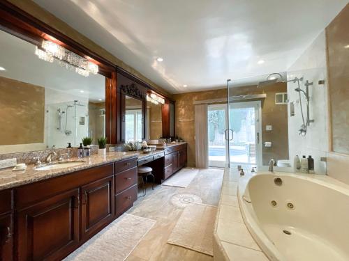 baño grande con bañera y espejo grande en Vacation Paradise - 6 BR Mansion on Top of Encino Hills en Topanga