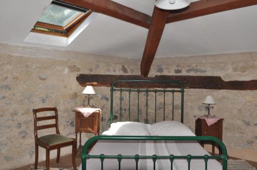 a bedroom with a green bed and a chair at Le Relais des Baronnies in Montjay