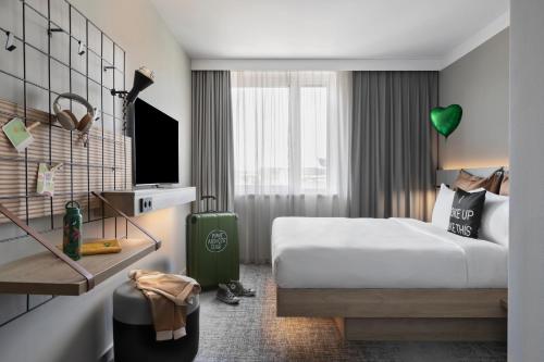 a hotel room with a bed and a tv at Moxy Vienna City East in Vienna