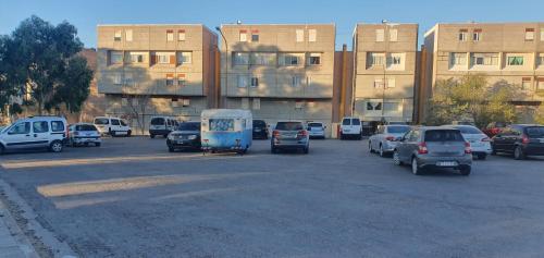 a parking lot with cars parked in front of buildings at Rock Apart in Puerto Madryn