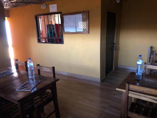 a dining room with two tables and two bottles of water at Residencial Meu Tio in Chimoio