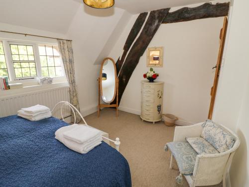 a bedroom with a blue bed and a chair and a mirror at Millstone House in Lutterworth