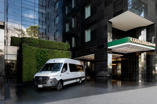 a white van parked in front of a building at Courtyard by Marriott Bogota Airport in Bogotá